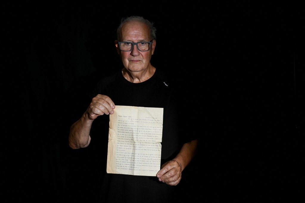 Photo by LUIS ROBAYO / AFP  Pablo Diaz, 67, who was kidnapped in La Plata on September 16, 1976 during the military dictatorship (1976-1983), poses for a photo holding a letter he wrote to his family during his captivity, in La Plata, Buenos Aires province, Argentina, on March 13, 2026.