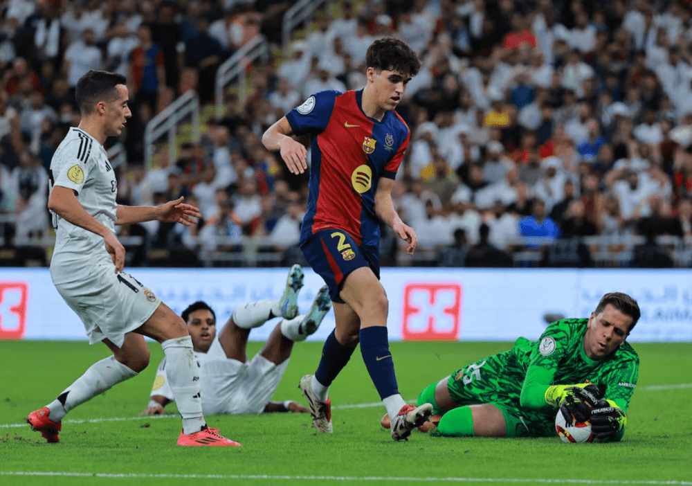 FC Barcelona's Wojciech Szczesny claims the ball ahead of Real Madrid's Lucas Vazquez and FC Barcelona's Pau Cubarsi. (REUTERS/Stringer)
