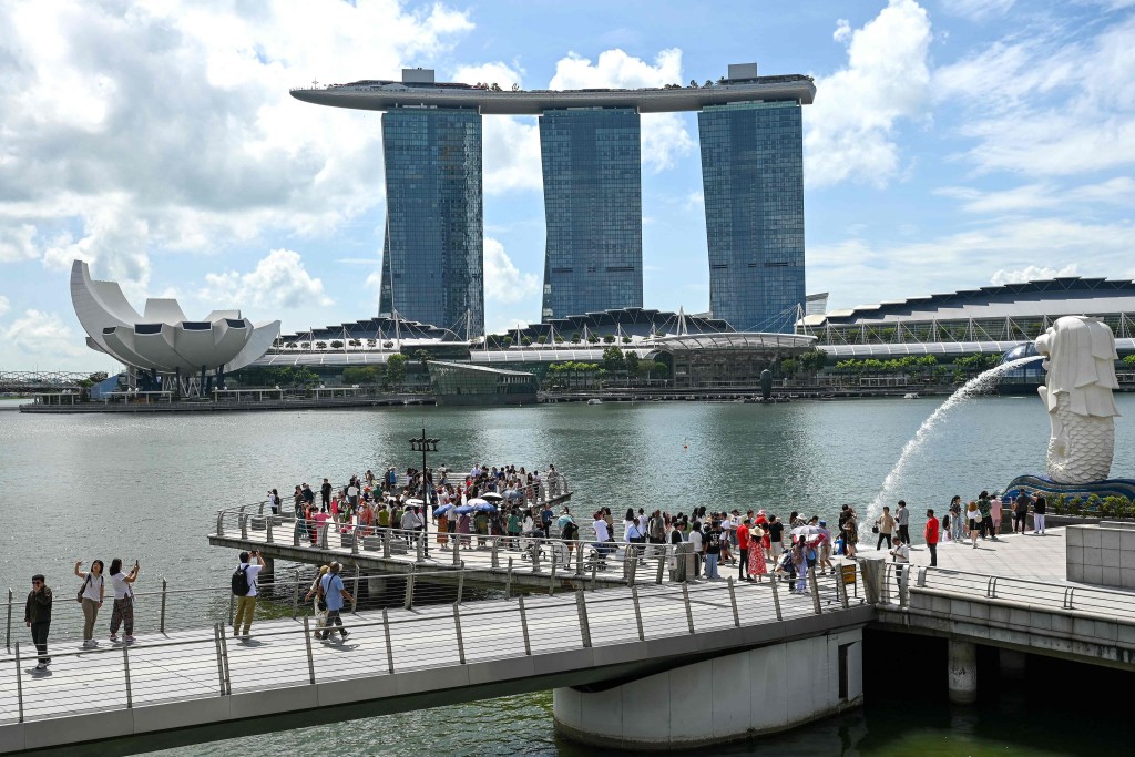 Visitors gather at the landmark Merlion Park on the Marina Bay waterfront in Singapore on March 14, 2025. (Photo by Roslan RAHMAN / AFP)