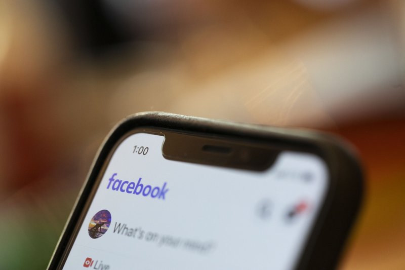 In this Aug. 11, 2019, file photo an iPhone displays a Facebook page in New Orleans. Facebook says hackers in China used fake accounts and impostor websites in a bid to break into the phones of Uyghur Muslims, Facebook announced Wednesday, March 24, 2021. In this Aug. 11, 2019, file photo an iPhone displays a Facebook page in New Orleans. Facebook says hackers in China used fake accounts and impostor websites in a bid to break into the phones of Uyghur Muslims, Facebook announced Wednesday, March 24, 2021.