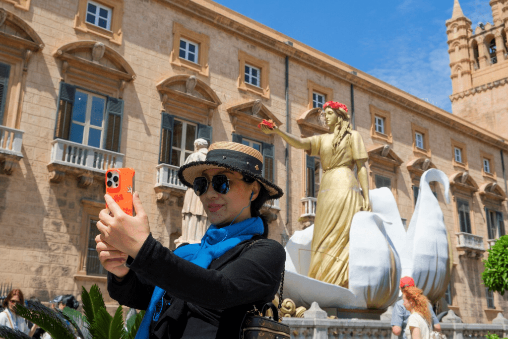 A tourist takes a selfie in front of the Palermo cathedral, in Palermo, Italy, May 14, 2025. REUTERS/Igor Petyx