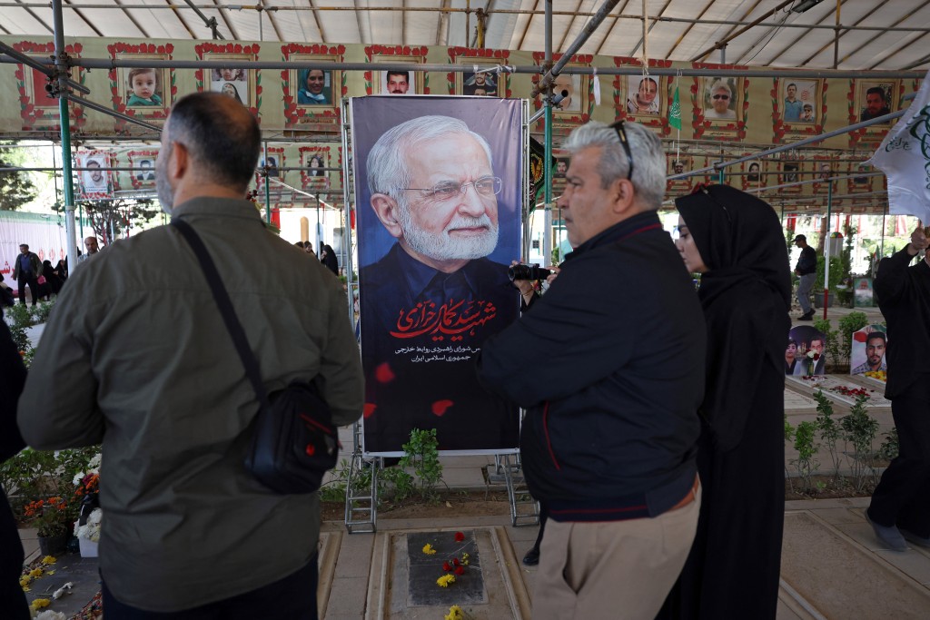 Photo by - / AFP  People pray over the grave of the former Iranian foreign minister Kamal Kharazi at the Behesht Zahra Cemetery in the south of Tehran on April 23, 2026.