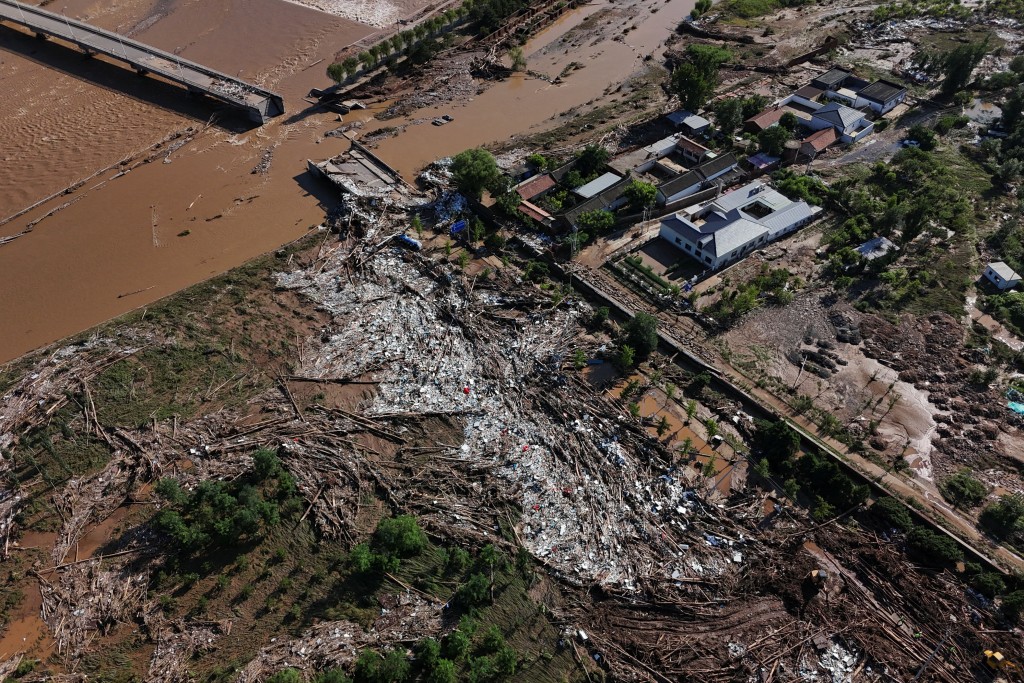 A drone view shows fallen trees and damage next to the overflowing Qingshui river after heavy rainfall flooded the area, in Miyun district of Beijing, China. (Reuters)