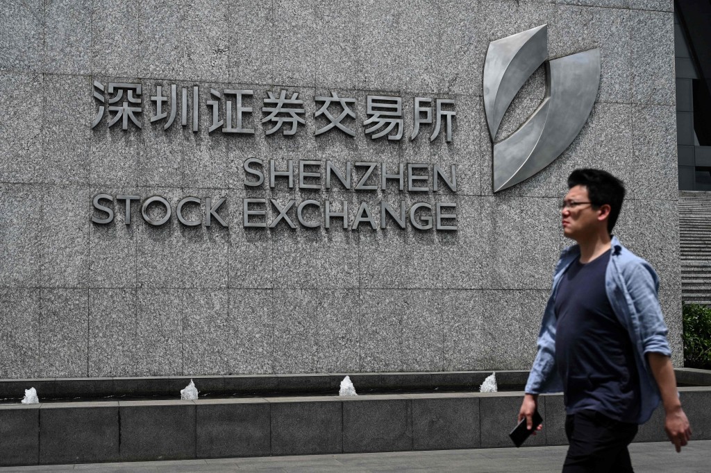 A man walks past the Shenzhen Stock Exchange in Shenzhen, in southern China Guangdong Province on April 14, 2025. AFP