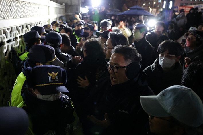 People react as police close the gate of the National Assembly in Seoul, South Korea. (Reuters)