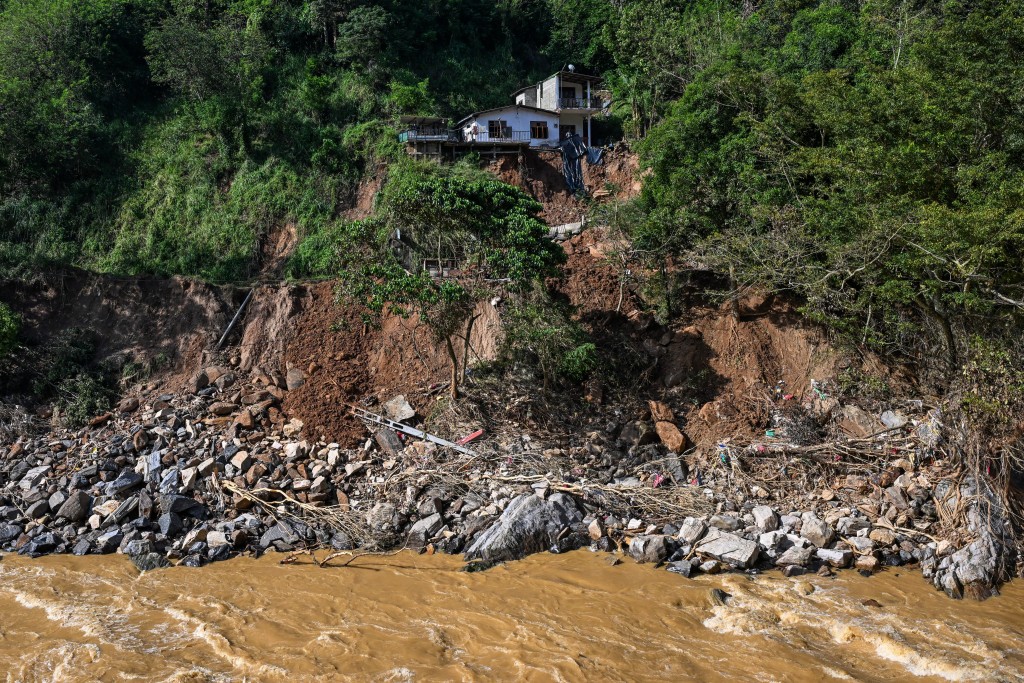 Photo by ISHARA S. KODIKARA / AFP  A damaged house is pictured at the site of a landslide in the aftermath of Cyclone Ditwah, in Warathenna, Kandy on December 4, 2025.