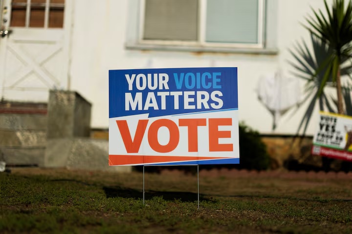An election sign encouraging people to vote is displayed in the front yard of a residential home in Encinitas, California, US, October 21, 2026. REUTERS/Mike Blake/File Photo