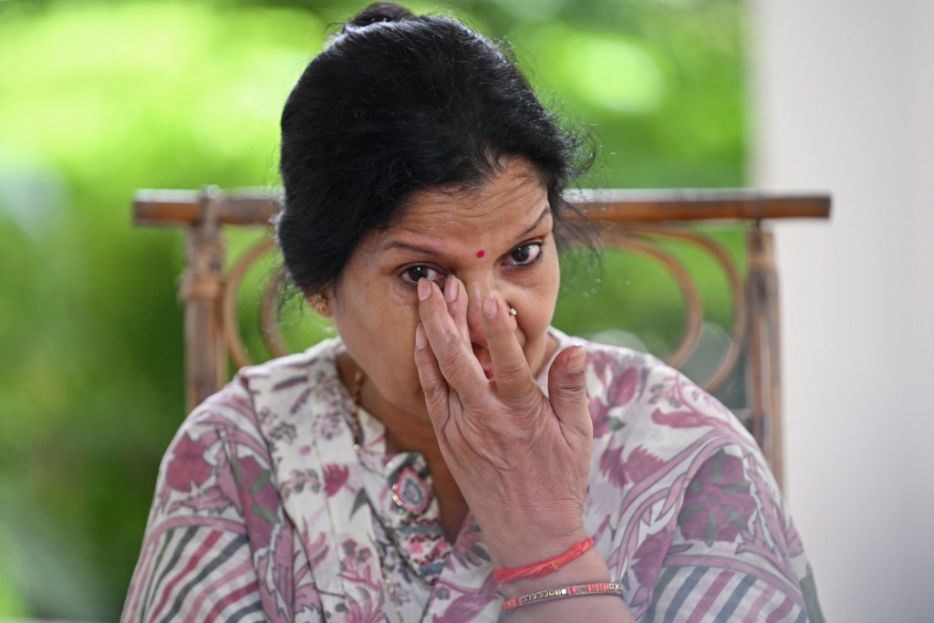 Photo by ARUN SANKAR / AFP  This photograph taken on August 14, 2026 shows Deepa Pant, mother of Indian merchant navy captain Ajay Pant, who remains in custody in Britain over sanctions-related offences linked to an alleged Russian 'shadow fleet' oil tanker, wiping her tears during an interview with AFP at Ramnagar in India's Uttarakhand state.