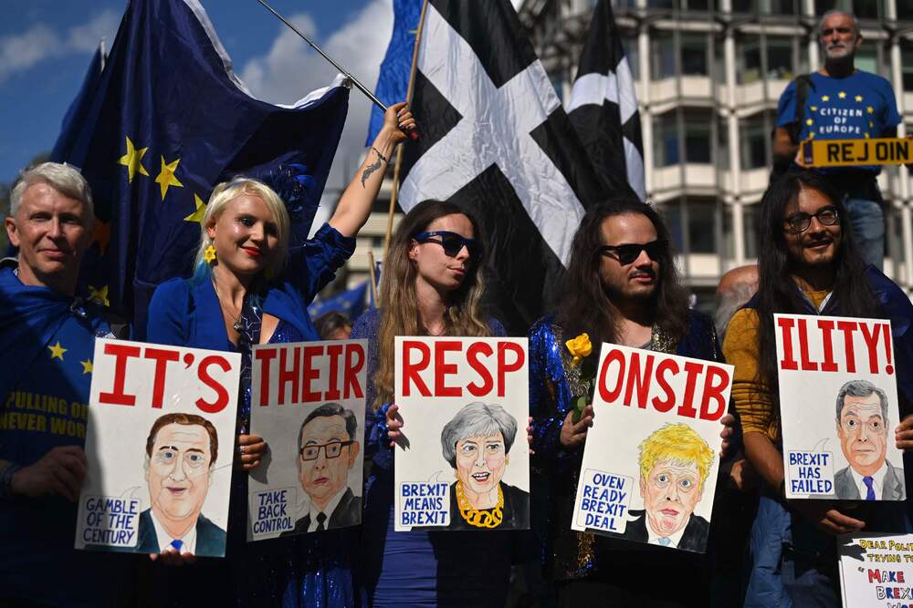 Protesters hold placards taking British politicians to task for Brexit, which they label a 'huge mistake.' AFP Protesters hold placards taking British politicians to task for Brexit, which they label a 'huge mistake.' AFP