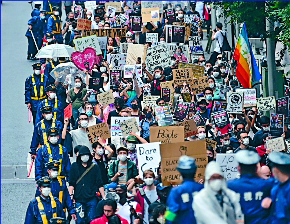Hundreds of marchers carry equality signs in Tokyo as a man is carried to police lines after clashing with protesters in London and a woman is escorted away by officers in Stockholm. AFP, REUTERS Hundreds of marchers carry equality signs in Tokyo as a man is carried to police lines after clashing with protesters in London and a woman is escorted away by officers in Stockholm. AFP, REUTERS