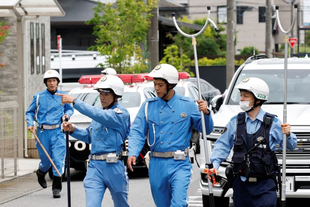 Policemen with sticks shields search for a bear at a residential area after a black bear was spotted in Utsunomiya, Tochigi Prefecture, Japan, June 9, 2026. REUTERS/Kim Kyung-Hoon