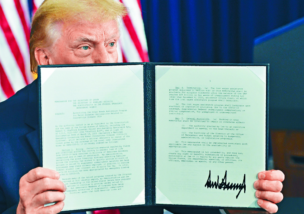 Donald Trump shows the signed executive orders, which Nancy Pelosi dismisses as 'meager' actions in the face of the crises facing Americans. AP Donald Trump shows the signed executive orders, which Nancy Pelosi dismisses as 'meager' actions in the face of the crises facing Americans. AP