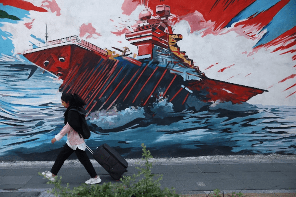 An Iranian woman walks next to a mural on a street in Tehran, Iran, May 11, 2026. Majid Asgaripour/WANA (West Asia News Agency) via REUTERS