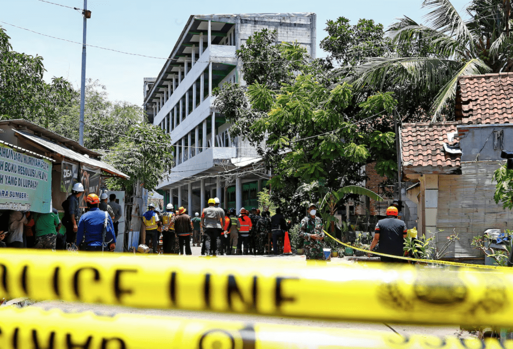 Rescuers gather near the site of a building collapse on Monday, where people remained trapped according to disaster mitigation agency, as the search and rescue operations continue at Al Khoziny Islamic boarding school in Sidoarjo, East Java province, Indonesia, October 2, 2025. (REUTERS/Dipta Wahyu)
