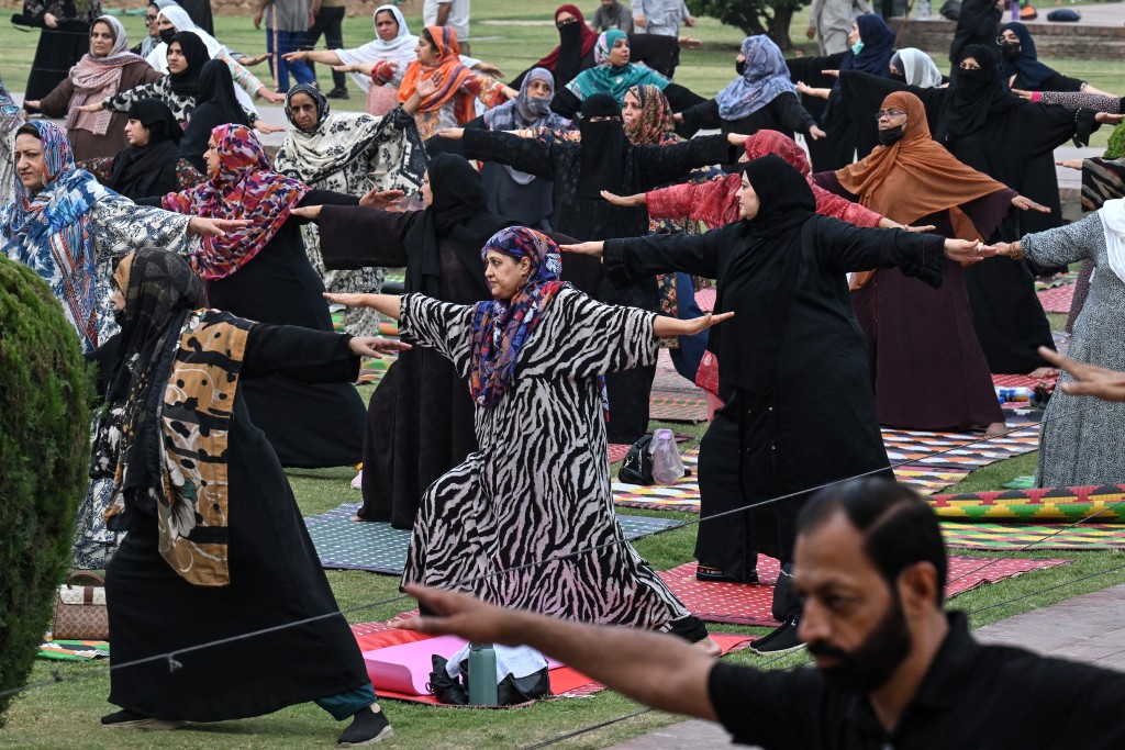 Muslim women take part in a yoga practice session on the eve of the International Yoga Day in Lahore on June 20, 2026. (Photo by Arif ALI / AFP)