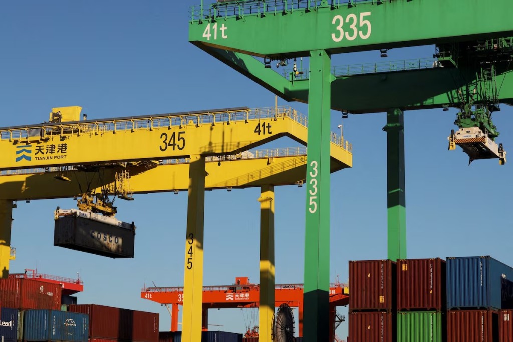 A gantry crane lifts a container at a port in Tianjin, China February 8, 2025. REUTERS
