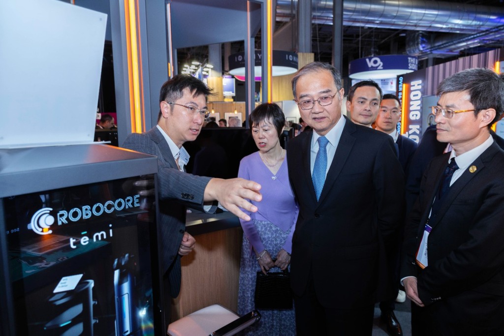 Roy Lim, left, introduces smart robot temi to Deng Li at the Hong Kong Pavilion, where 18 startups show off their products.