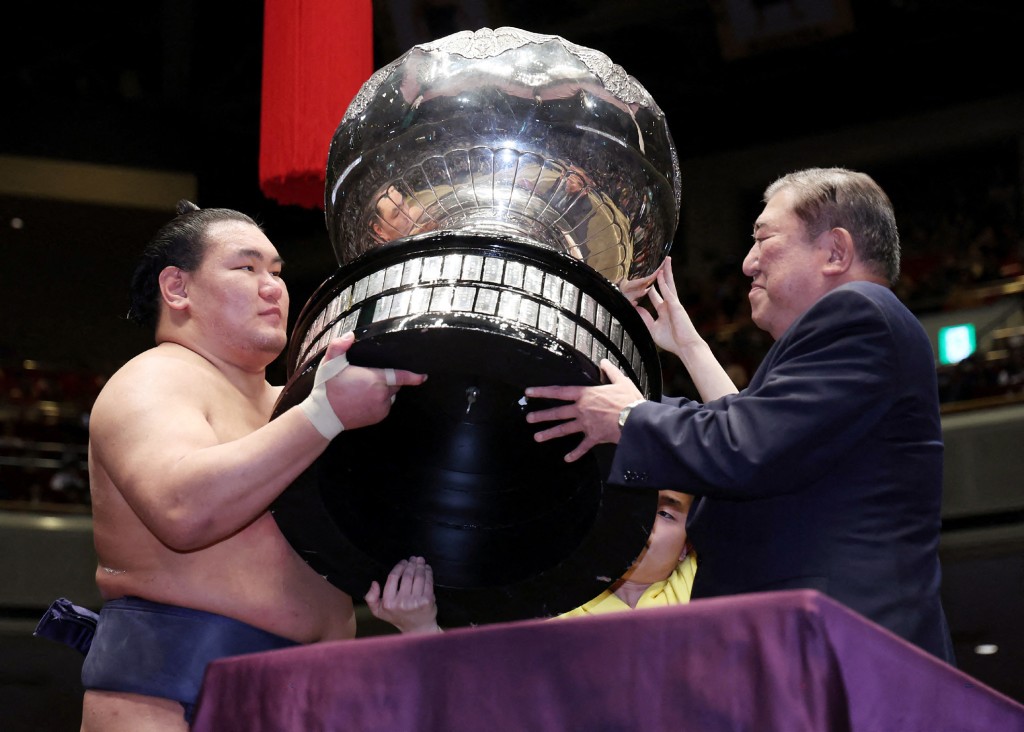 Photo by STR / JIJI PRESS / AFP  This photo taken on January 26, 2025 shows former Japan's Prime Minister Shigeru Ishiba (R) presenting the Prime Minister's Cup to Mongolian sumo wrestler Hoshoryu during the awards ceremony after winning fo the New Year Grand Sumo Tournament at the Ryogoku Kokugikan in Tokyo.