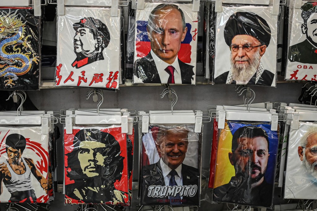 T-shirts depicting Russia's President Vladimir Putin (top, C), US President Donald Trump (bottom, C) and Ukraine's President Volodymyr Zelensky (bottom, 2nd R) are seen at a shop in an underground commercial district in Shanghai on May 18, 2026. (Photo by Jade GAO / AFP)