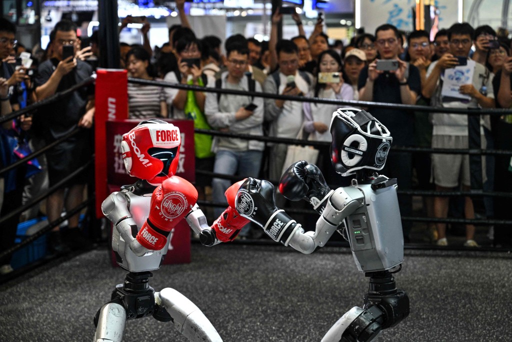 Humanoid robots controlled by a remote control by Unitree Robotics take part in a fight during the World Artificial Intelligence Conference (WAIC) in Shanghai on July 18, 2026. AFP