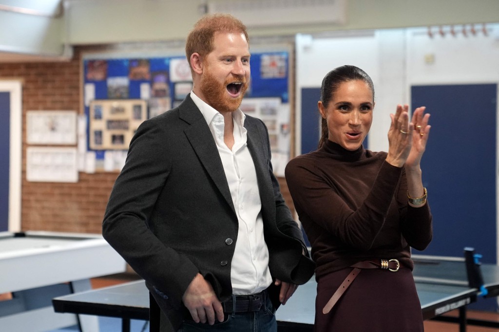 Britain's Prince Harry and his wife Meghan react during a visit to in Nottingham on October 15. (AFP)