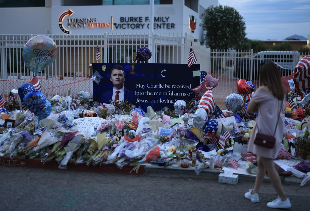 A person visits the makeshift memorial for Charlie Kirk outside the headquarters of Turning Point USA on September 18, 2025, in Phoenix, Arizona.  Joe Raedle/Getty Images/AFP