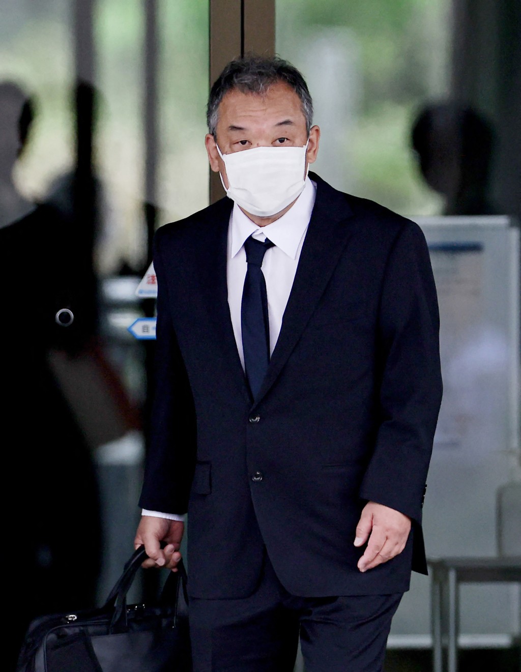 Photo by JIJI PRESS / JIJI PRESS / AFP Seiichi Katsurada, president of a Japanese sightseeing boat company whose vessel Kazu I was involved in a deadly 2022 accident, enters the Kushiro District court for sentencing in Kushiro City on June 17, 2026.