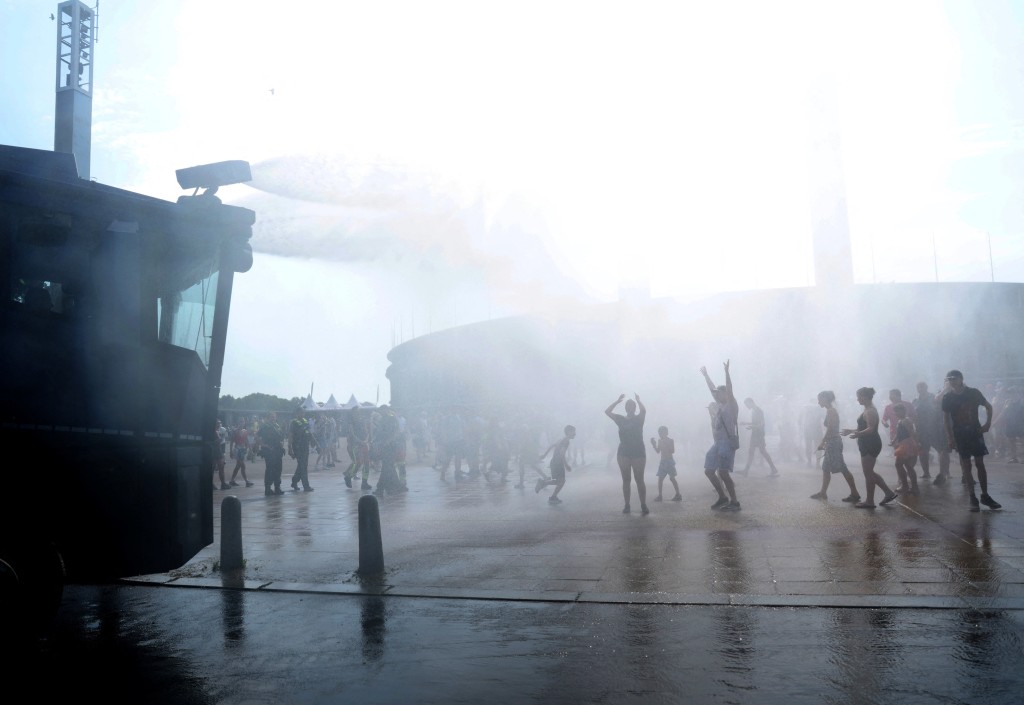 People enjoy the water sprayed by a police water cannon in front of of the Olympic stadium Olympiastadion during the ongoing heatwave in Berlin, Germany (Reuters)