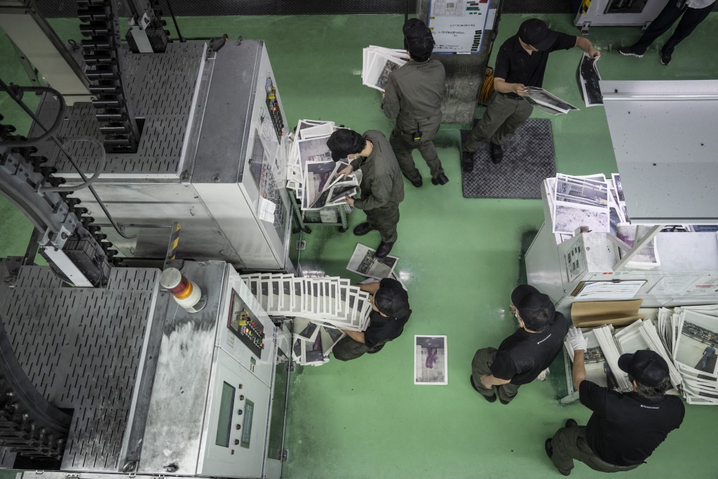 Photo by YUICHI YAMAZAKI / AFP  This picture taken on March 19, 2026 shows staff members printing photographer Kazuma Obara’s work titled “The Newspaper” at the Kyoto Shimbun factory in Kumiyama, Kyoto prefecture.
