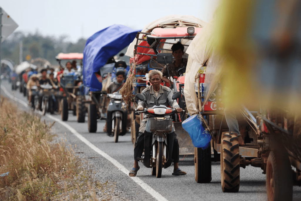 Vehicles carrying people who evacuate, amid deadly clashes between Thailand and Cambodia along a disputed border area, wait in a long line to get into a refugee camp in Chong Kal, Oddar Meanchey Province, Cambodia, December 10, 2025. REUTERS/Kim Hong-Ji