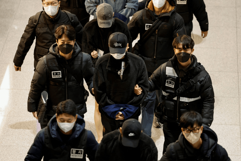 Police officers escort South Koreans allegedly involved in scam operations in Cambodia after being forcibly repatriated from Cambodia, at Incheon International Airport in Incheon, South Korea January 23, 2026. REUTERS/Kim Soo-hyeon