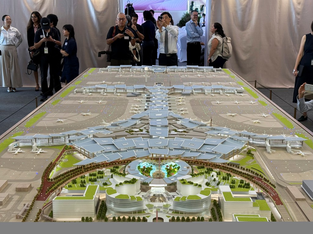 People take photos of a model of Changi Airport Terminal 5, on the sidelines of a groundbreaking ceremony, at the Changi Airport Terminal 5 site, in Singapore, May 14, 2025. (Reuters)