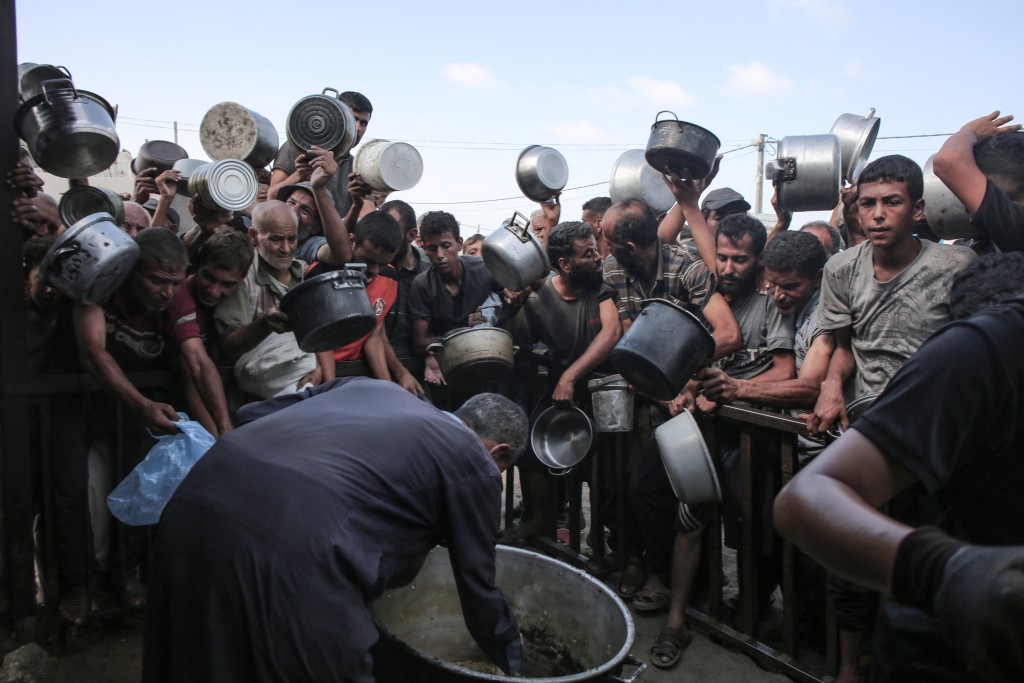 Displaced Palestinians elbow their way in front of a community kitchen in Khan Yunis in the southern Gaza Strip on September 19, 2025. The Israeli military warned on September 19, that it will operate with "unprecedented force" in Gaza City, urging residents to flee southwards while announcing the closure of a temporary evacuation route opened 48 hours earlier. (Photo by AFP)