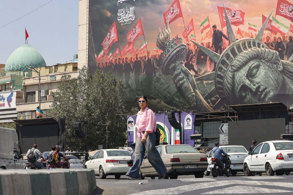 Photo by ATTA KENARE / AFP  People walk past an anti-US billboard at Enghelab Square in central Tehran on September 2, 2026.