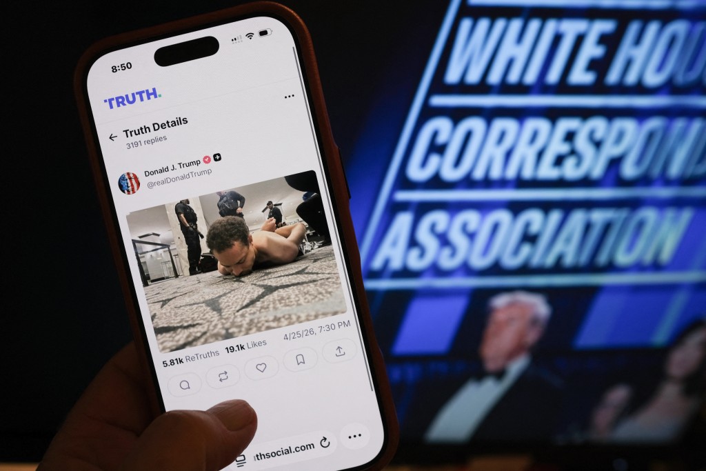 Photo by CHRIS DELMAS / AFP  This illustration photo taken in Los Angeles shows a phone with a Truth Social post by US President Donald Trump displaying an image of the alleged suspect in a shooting incident at the White House Correspondents’ Dinner on the ground after being apprehended on April 25, 2026.