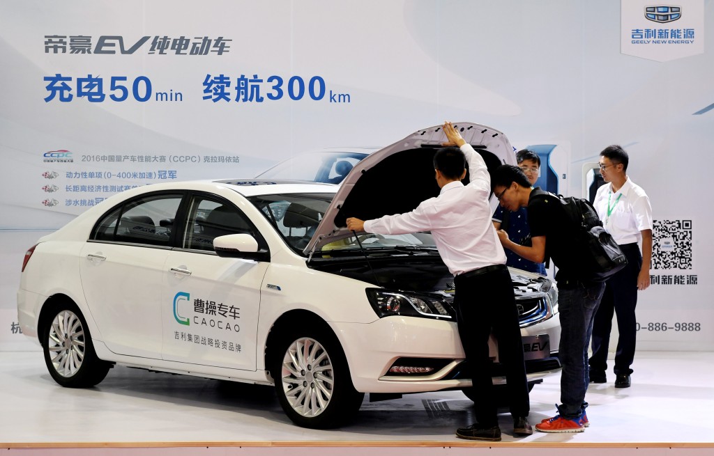 Men look at an electric vehicle of Caocao Zhuanche, a chauffeur ride-hailing platform backed by Zhejiang Geely Holding Group, at a new energy vehicle (NEV) trade fair in Zhengzhou, Henan province, China September 23, 2016. Picture taken September 23, 2016. REUTERS/Stringer 