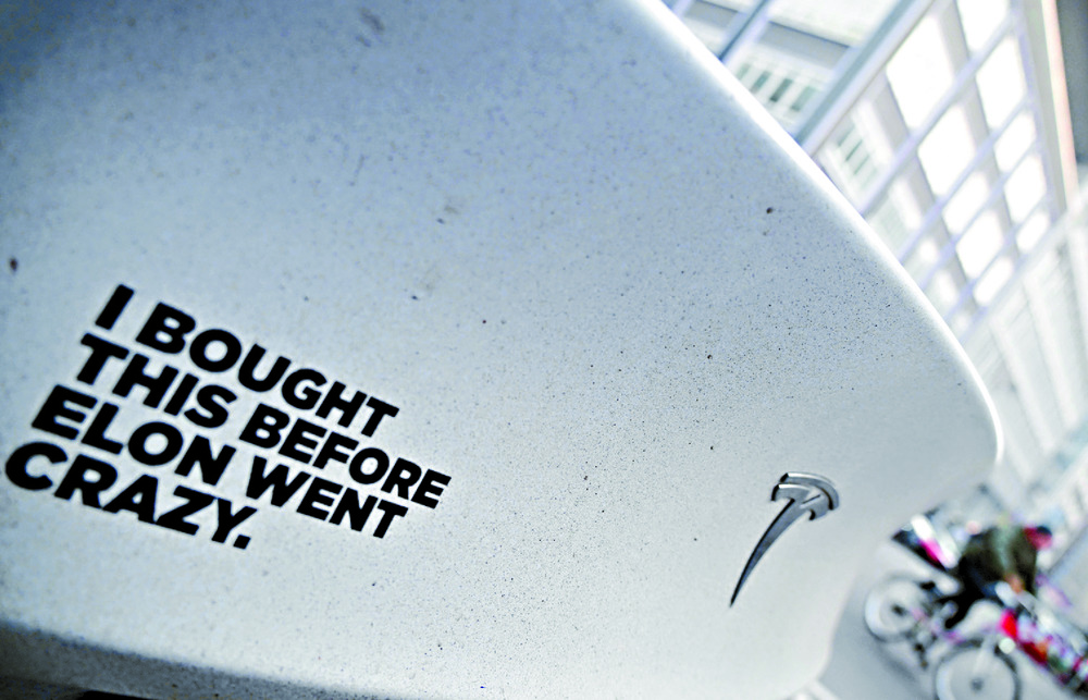 An 'Elon went crazy' sticker is plastered on a Tesla in Berlin as people protest outside a Tesla store in New York on International Women's day. AFP, REUTERS An 'Elon went crazy' sticker is plastered on a Tesla in Berlin as people protest outside a Tesla store in New York on International Women's day. AFP, REUTERS