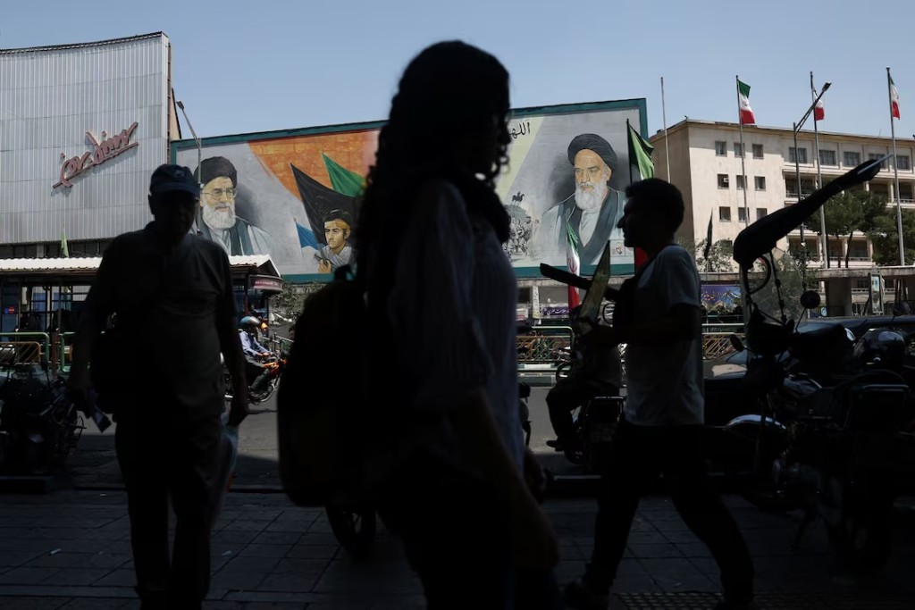 People walk past a mural depicting the late leader of the Islamic Revolution, Ayatollah Ruhollah Khomeini, and the late Iran's Supreme Leader Ayatollah Ali Khamenei, on a street in Tehran, Iran, June 9, 2026. Majid Asgaripour/WANA (West Asia News Agency) via REUTERS
