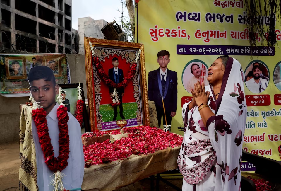 Sita Patni, a survivor and the mother of Akash Patni, 14, who died in an Air India Boeing 787-8 Dreamliner crash on June 12, 2025, mourns in front of her son's portrait near the crash site during the first anniversary in Ahmedabad, India, June 12, 2026. REUTERS/Amit Dave 