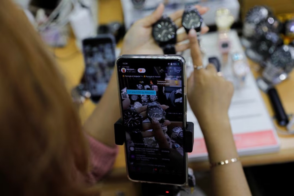 A shopkeeper sells watches live on a social media platform at the International Trade Center (ITC) mall in Jakarta, Indonesia, September 27, 2023. REUTERS/Willy Kurniawan