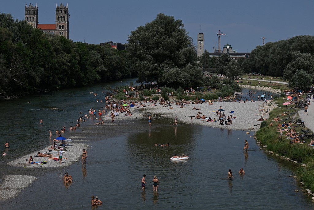 People enjoy the cool waters of the Isar, during a heatwave in Munich, Germany (Reuters)