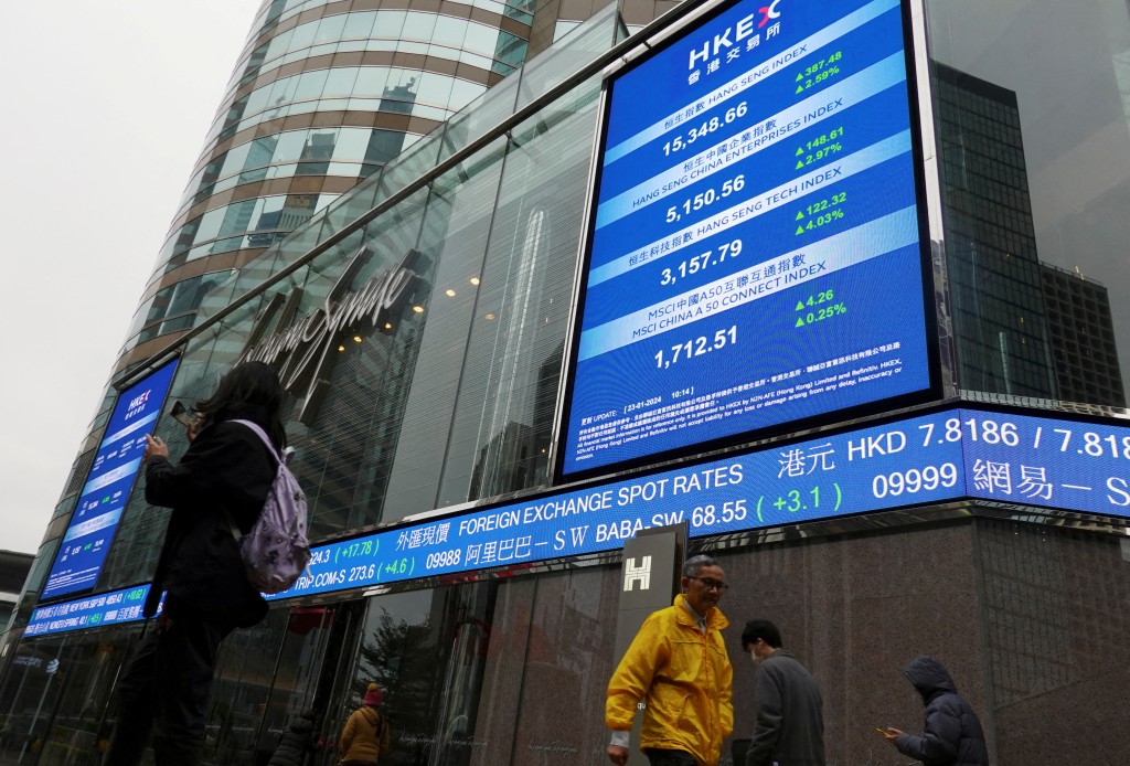 People walk past screens displaying the Hang Seng stock index and stock prices outside the Exchange Square in Hong Kong, China January 23, 2024. REUTERS/Joyce Zhou/File Photo