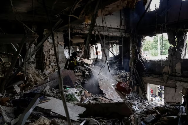 A firefighter works at the site of an apartment building hit by a Russian drone strike. REUTERS/Sofiia Gatilova