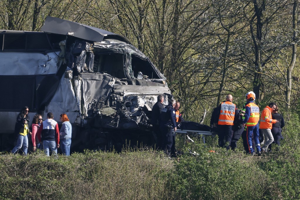 Firefighters and Police officers transport a person from the wreckage of a TGV train after its collision at a level crossing with a lorry between Bethune and Lens, in Bully-les-Mines, in the Pas-de-Calais region, northern France on April 7, 2026. (AFP)