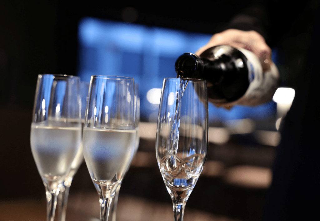 A staff at TPB, a sake bar run by Tokyo Port Brewing, pours sake in a bottle into customers’ glass in the bar in Tokyo, Japan July 12, 2024. REUTERS/Kim Kyung-Hoon/File Photo