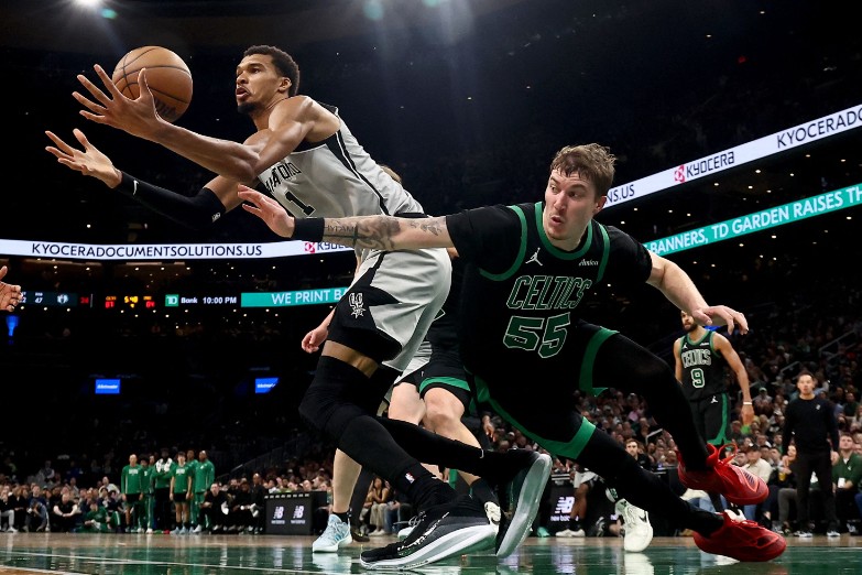 Victor Wembanyama, left, reaches for the loose ball under pressure from Baylor Scheierman of the Celtics. AFP