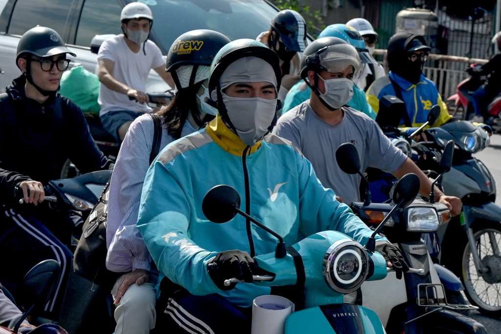 Photo by NHAC NGUYEN / AFP A motorist rides a Vinfast electric motorbike along a street in Hanoi on May 13, 2026.