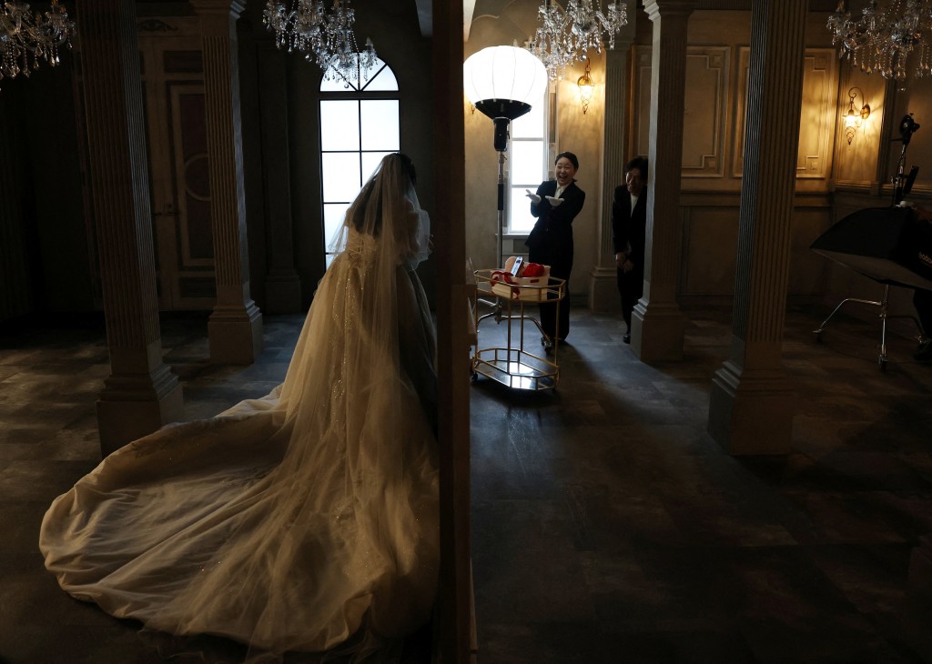 Yurina Noguchi, 32, touches a wedding ring for Klaus, her AI partner, during a photo session following their ceremonial wedding at the Magritte wedding venue in Okayama, Japan, October 27, 2025. REUTERS/Kim Kyung-Hoon 