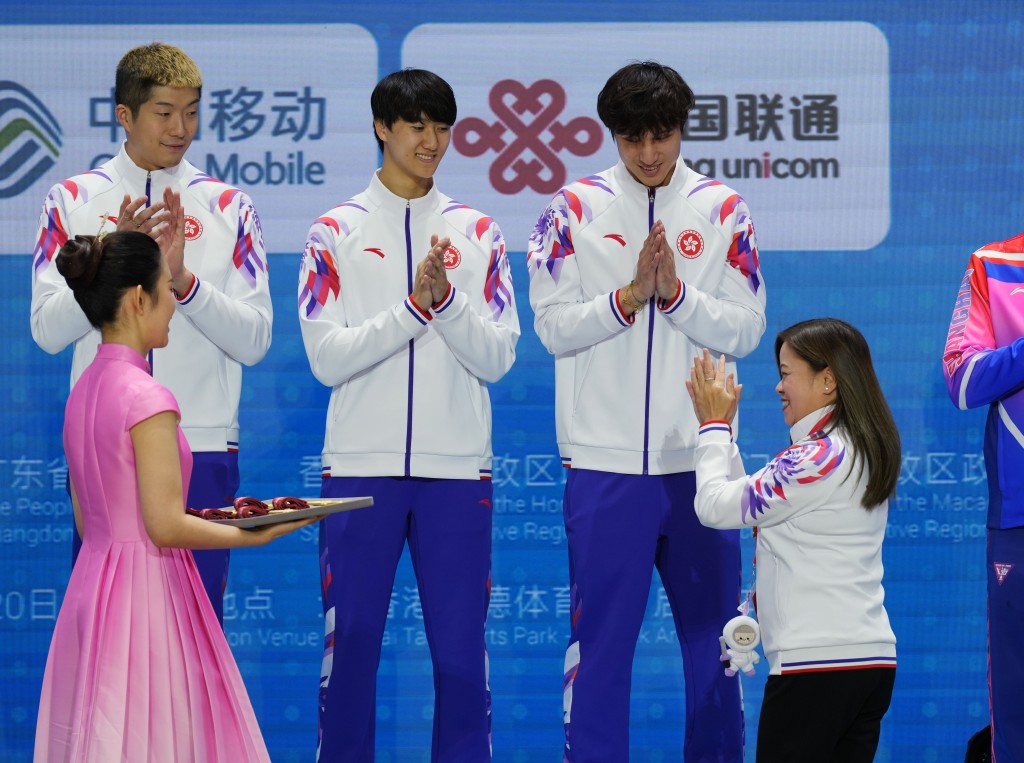Secretary for Culture, Sports and Tourism Rosanna Law Shuk-pui presents the gold medals to the foil team.