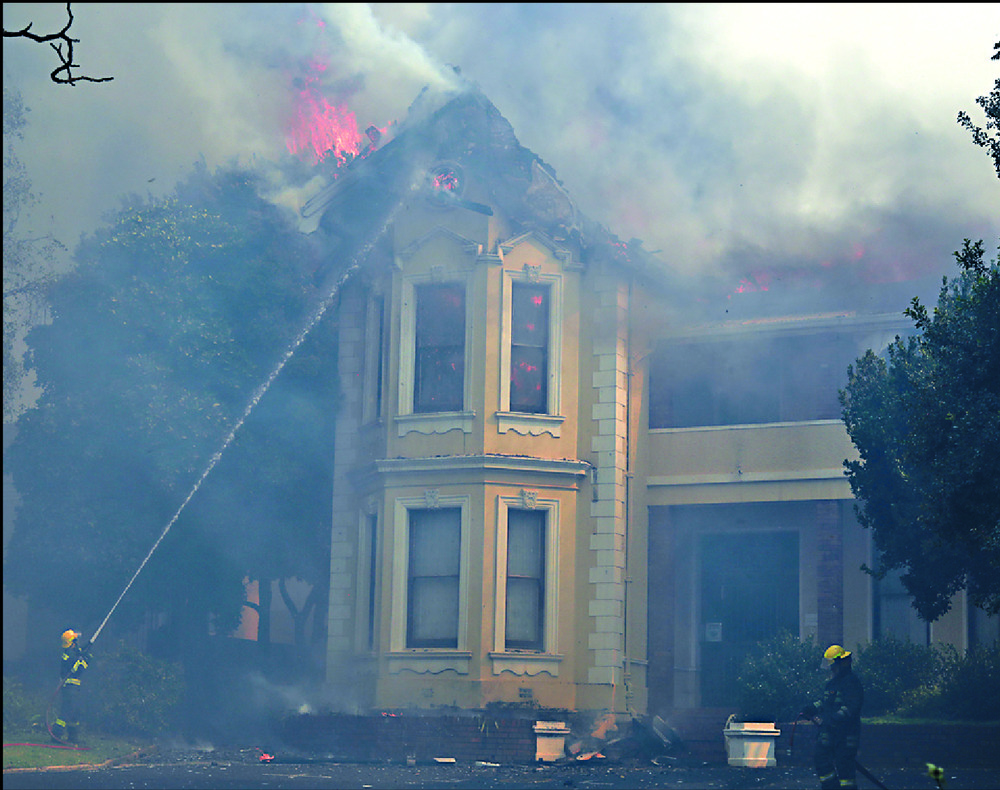 Firefighters douse a burning building at the University of Cape Town campus. AP Firefighters douse a burning building at the University of Cape Town campus. AP